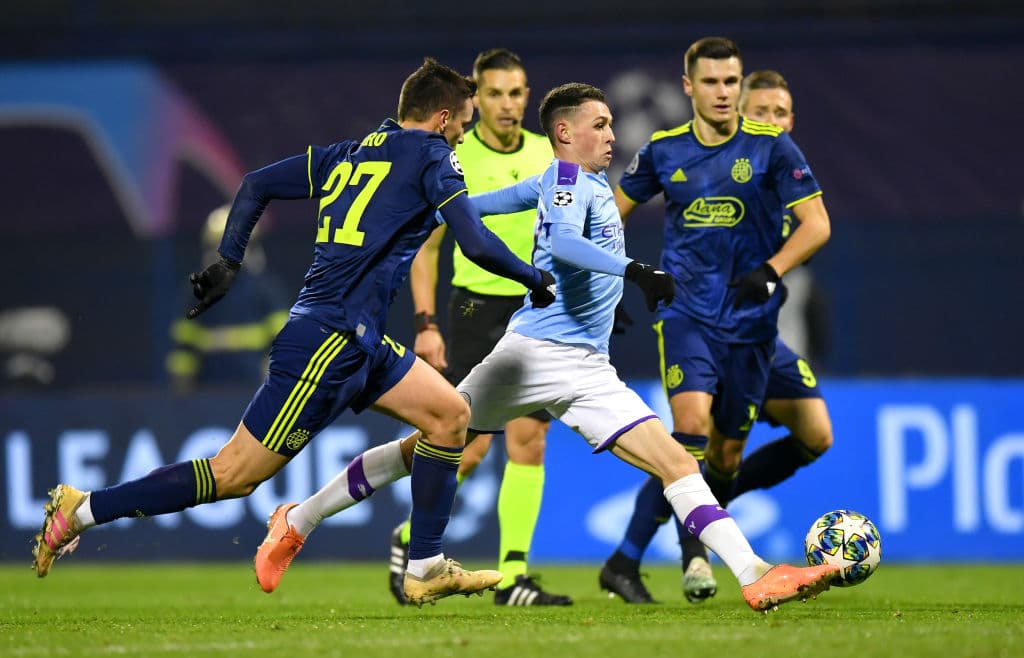 Phil Foden se cuela entre dos rivales que no pueden quitarle el balón.