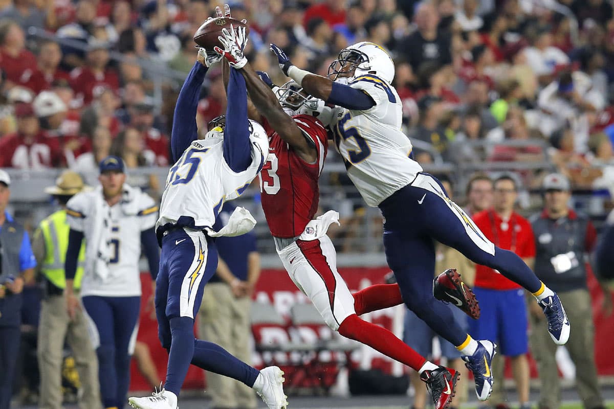 #4. TRES POR EL BALÓN: El WR de los Arizona Cardinals, Jaron Brown (13), no se pudo llevar este envío ante la presión de los defensivos de los San Diego Chargers, Richard Crawford y Darrell Stuckey