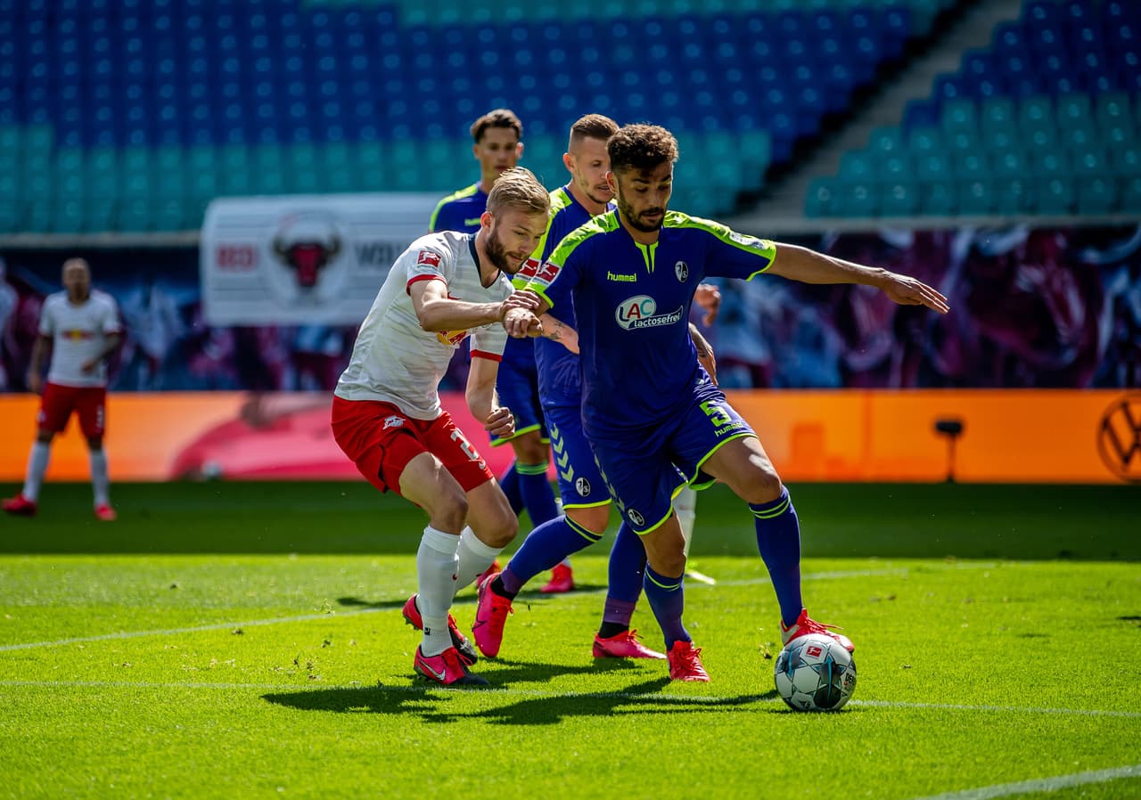 Konnrad Laimer hace presión alta y trata de robarle el balón al defensor del Freiburg Manuel Gulde.