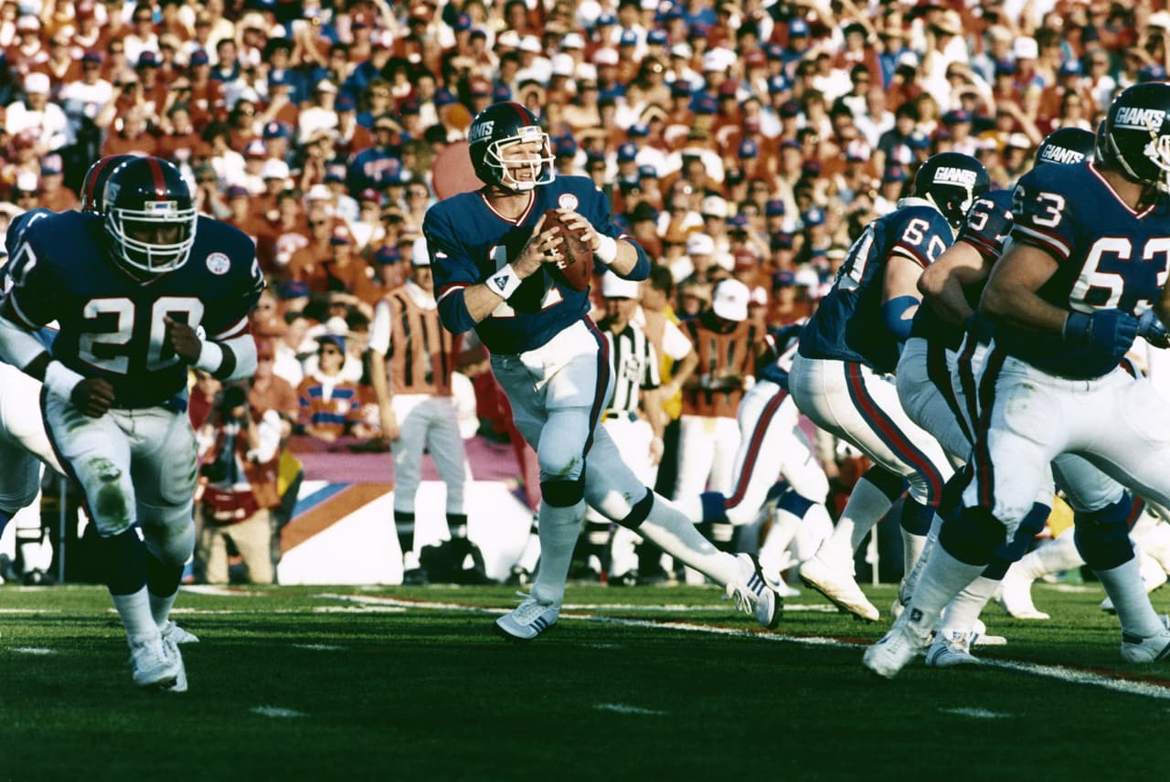 PHIL SIMMS - Super Bowl XXI Primera selección de los New York Giants en 1979. Tuvo muchos problemas de lesiones e inconsistencia. La llegada del coach Bill Parcells en 1983 encausó a buen camino la carrera de Simms. Tardo 7 años en ser campeón, 4 de ellos bajo el mando de Parcells.