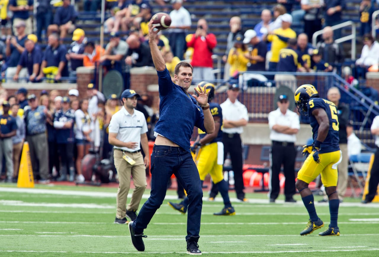 Former Michigan and currently suspended New England Patriots quarterback Tom Brady throws the football on the field before an NCAA college football game against Colorado at Michigan Stadium in Ann Arbor, Mich., Saturday, Sept. 17, 2016. (AP Photo/Tony Ding)