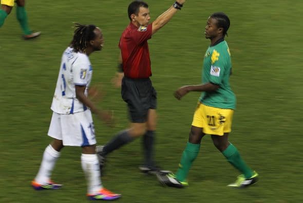 Luton Shelton de Jamaica recibe la tarjeta amarilla por parte del árbitro salvadoreño Joel Aguilar.