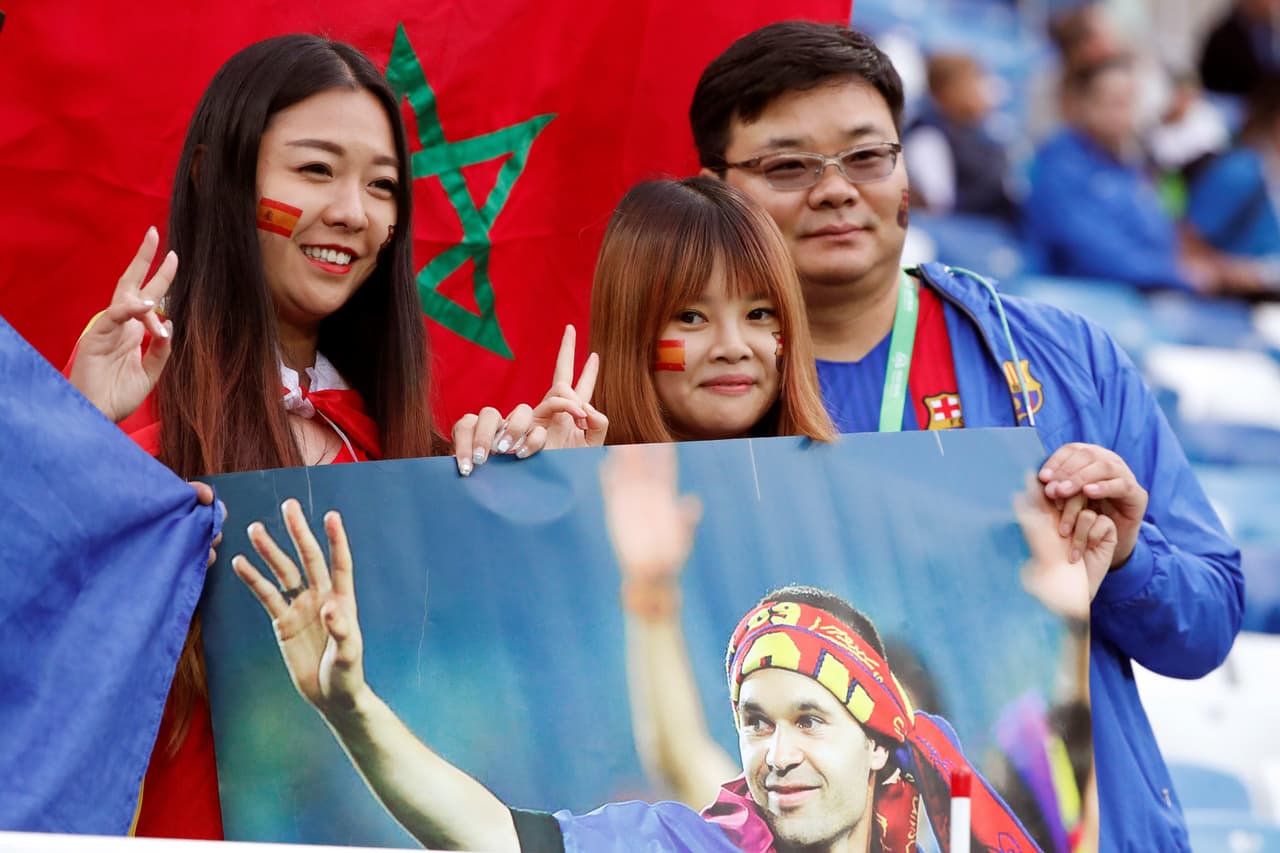 MUN35-12. KALININGRADO (RUSIA), 25/06/2018.- Aficionados asiáticos animan a España con un cartel del jugador Andrés Iniesta, antes del partido España-Marruecos, del Grupo B del Mundial de Fútbol de Rusia 2018, en el Estadio de Kaliningrado de Kaliningrado, Rusia, hoy 25 de junio de 2018 (RUSSIA SOCCER FIFA WORLD CUP, Spain, Morocco, Kaliningrad). EFE/Javier Etxezarreta [ATENCIÓN EDITORES: Sólo Uso editorial. Prohibido su uso en referencia con entidad comercial alguna. Prohibido su uso en alertas, descargas o mensajería multimedia en móviles. Las imágenes deberán aparecer como fotografías congeladas y no podrán emular la acción del juego mediante secuencias o fotomontajes. Ninguna imagen publicada podrá ser alterada, mediante texto o imagen superpuesta, en el caso de que (a) intencionalmente oculte o elimine el logotipo de un patrocinador o (b) añada y/o cubra la identificación comercial de terceras partes que no esté oficialmente asociada con la Copa Mundial de la FIFA.]