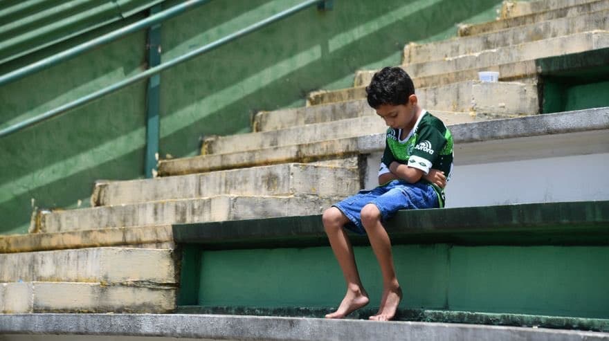 Un pequeño aficionado en las gradas del estadio del Chapecoense, visiblemente afectado por el accidente que sufrió su equipo.