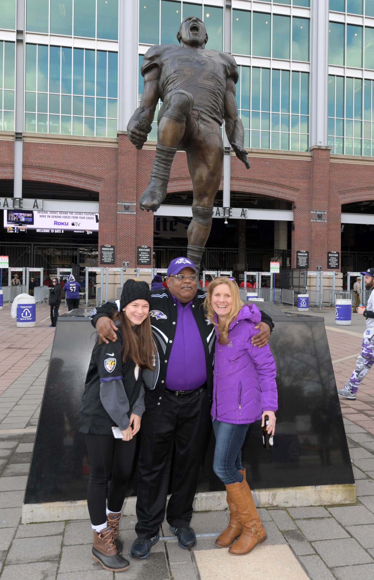 Una familia ante la estatua del legendario Ray Lewis de los Baltimore Ravens.