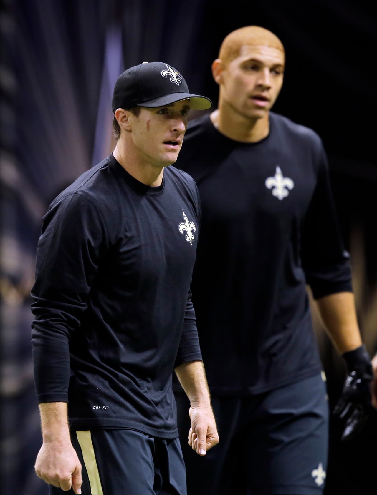 New Orleans Saints quarterback Drew Brees and tight end Jimmy Graham, behind, warm up before an NFL football game in New Orleans, Sunday, Sept. 21, 2014. (AP Photo/Bill Haber)