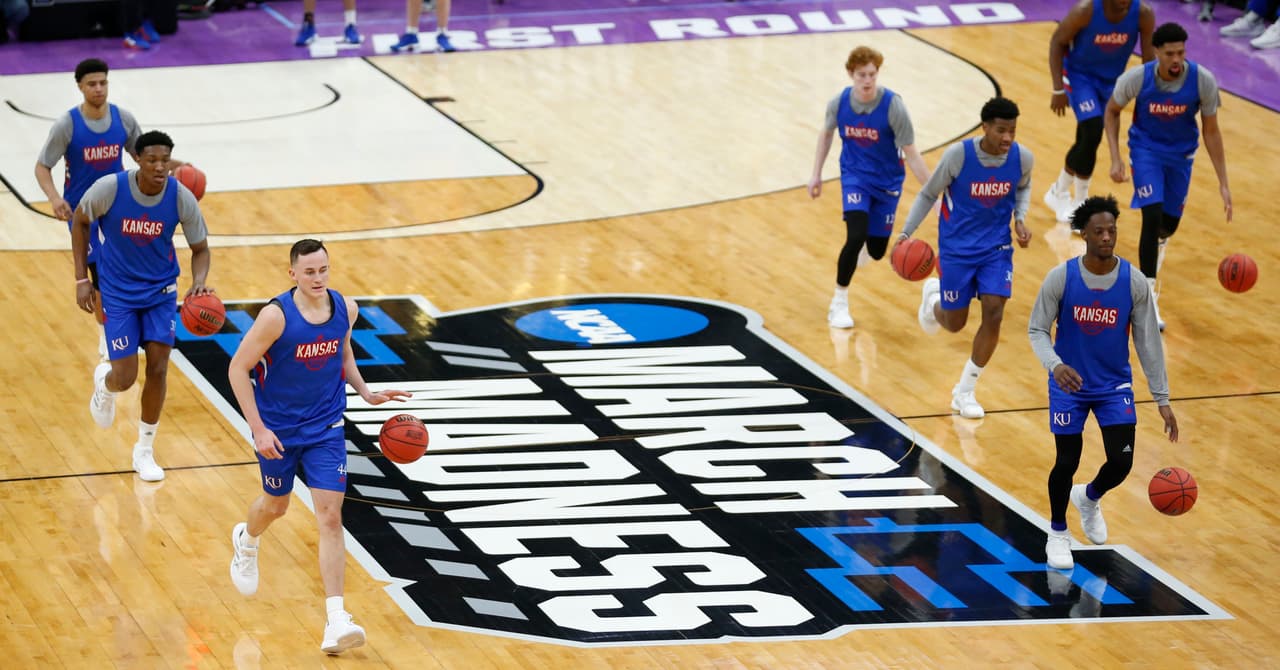 En la imagen aparecen los jugadores de los Kansas Jayhawks calentando en aras de prepararse para su debut en el Torneo de la NCAA este jueves ante la Universidad de Northeastern en Salt Lake City, Utah. Pero no son los únicos.