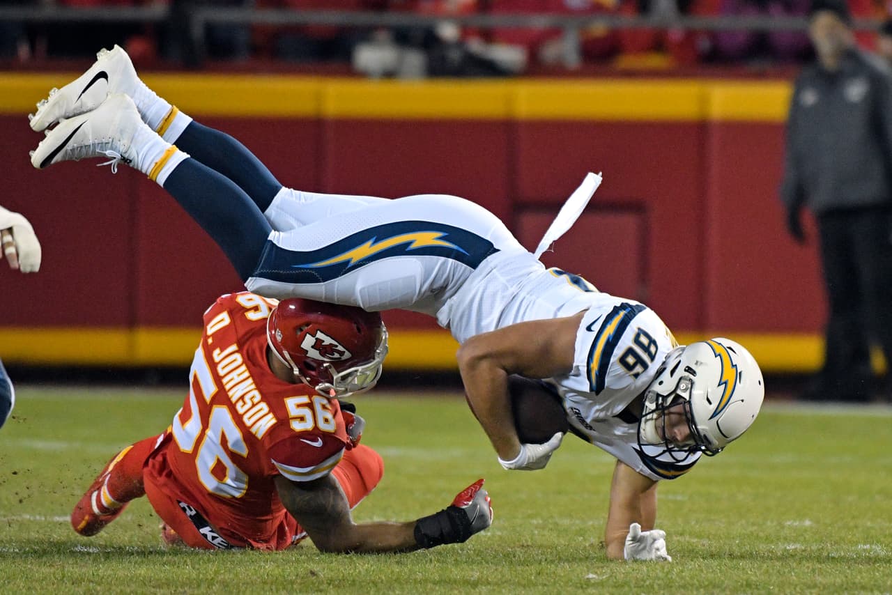 Los Angeles Chargers tight end Hunter Henry (86) is tackled by Kansas City Chiefs linebacker Derrick Johnson (56) during the first half of an NFL football game in Kansas City, Mo., Saturday, Dec. 16, 2017. (AP Photo/Ed Zurga)