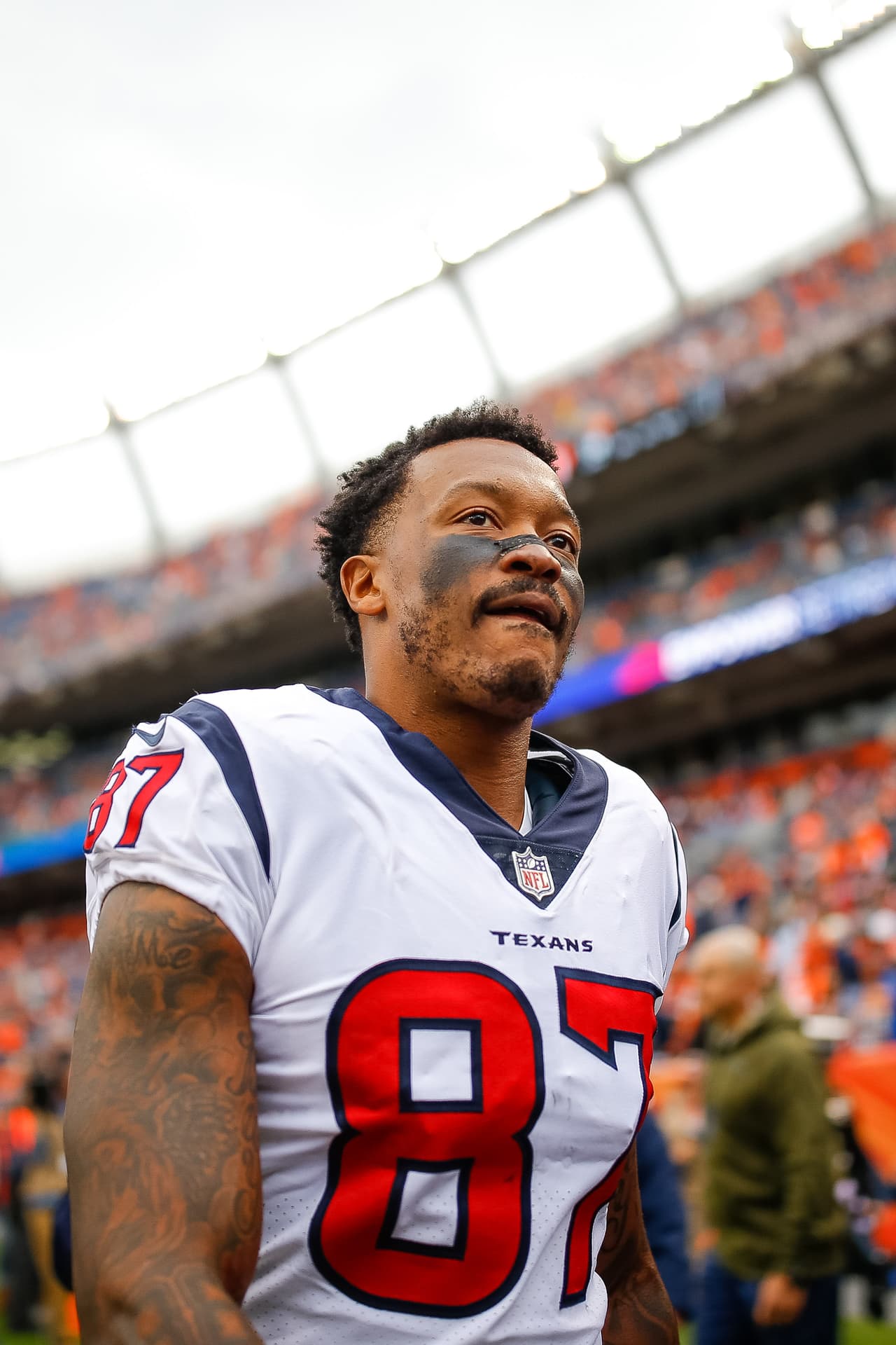 El receptor abierto Demaryius Thomas con el #87 de los Houston Texans camina en el campo des´pues de calentar antes de un partido ante los Denver Broncos.