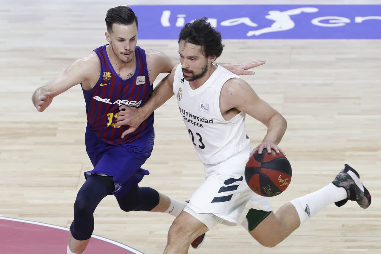 El base del Real Madrid, Sergio Llull (derecha), con el balón ante el jugador francés del FC Barcelona Lassa, Thomas Heurtel (izquierda).
