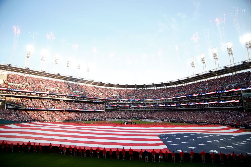 Y mientras se interpretaba el himno nacional de los Estados Unidos de América en Progressive Field, una gigantésca bandera con las barras y las estrellas era expandida a lo largo del outfield, a instantes de que diera comienzo el gran juego.