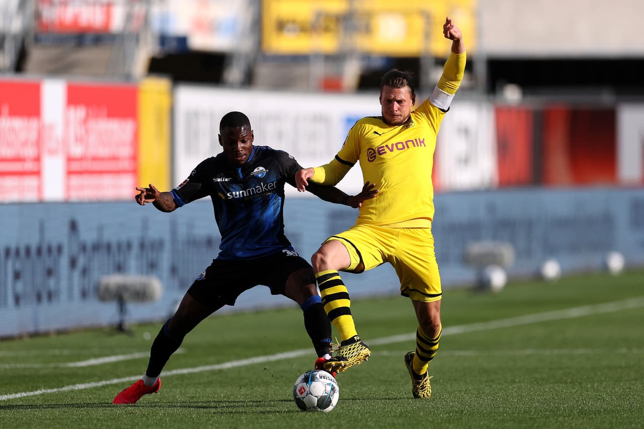 Lukasz Piszczek amarga a Streli Mamba y se queda con la pelota en su terreno.