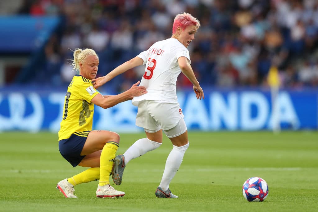 La peculiar Sophie Schmidt de Canadá, con su colorida cabellera, es presionada por la sueca Caroline Seger en los primeros minutos del partido.