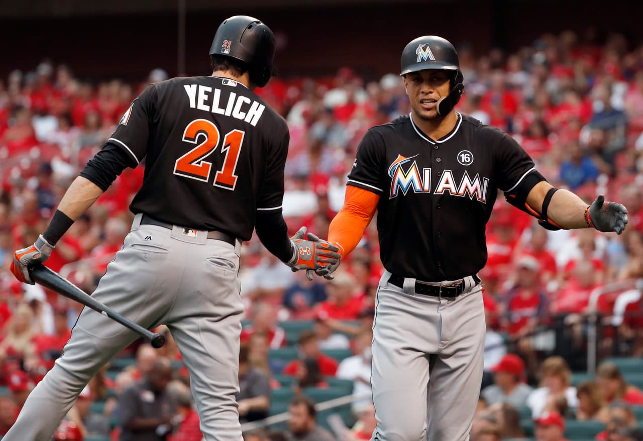 El jugador de los Marlins de Miami Giancarlo Stanton (derecha) recibe la felicitación de su compañero Christian Yelich tras disparar un jonrón solitario durante el primer inning del juego de la MLB que enfrentó a su equipo con los Cardenales de San Luis, el 5 de julio de 2017, en St. Louis. (AP Foto/Jeff Roberson)