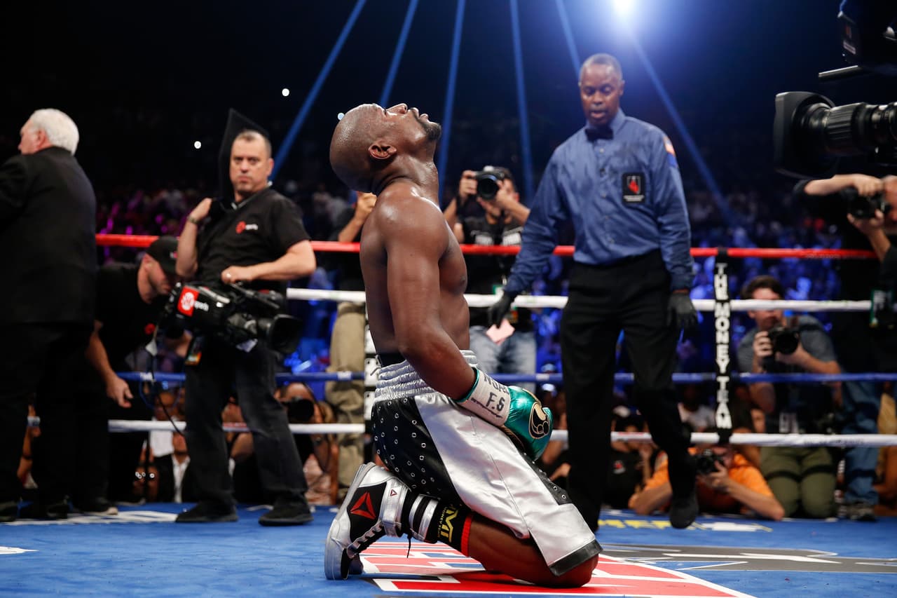 Floyd Mayweather posa de rodillas en medio del ring luego de acabar su pelea con Andre Berto.
