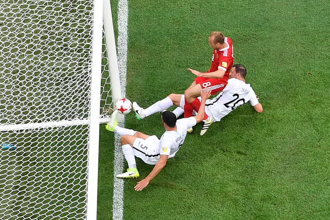 Russia's midfielder Denis Glushakov scores the match's first goal as he is tackled by New Zealand's defender Michael Boxall (L) and New Zealand's defender Tommy Smith during the 2017 Confederations Cup group A football match between Russia and New Zealand at the Krestovsky Stadium in Saint-Petersburg on June 17, 2017. / AFP PHOTO / FRANCOIS XAVIER MARIT (Photo credit should read FRANCOIS XAVIER MARIT/AFP/Getty Images)
