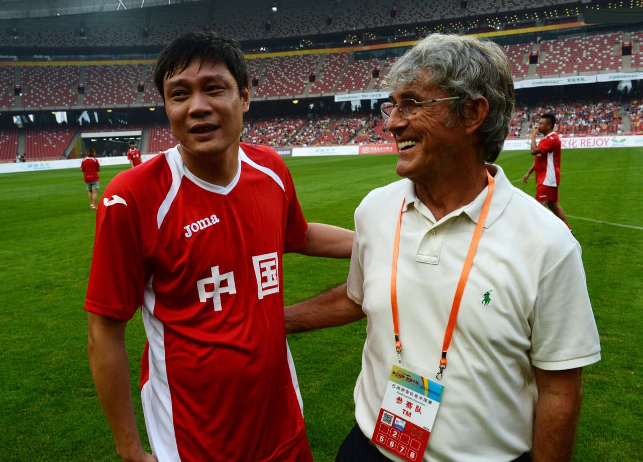Chinese football icon Fan Zhiyi (L) and former Chinese football coach Bora Milutinovic (R) smile before the China and Brazil Legends game at the Olympic Stadium, also known as the 'Bird's Nest, in Beijing on August 10, 2013. The game won by Brazil 2-1 stars football legends from previous World Cup campaigns and the Chinese side will once again be led by Serbian coach Bora Milutinovic, who took China to its only World Cup in 2002. AFP PHOTO/Mark RALSTON (Photo credit should read MARK RALSTON/AFP/Getty Images)