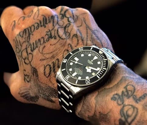 Destacan el Cristo en su costado derecho, el ángel en su brazo, el nombre de su pareja en la mano derecha y el ángel en su espalda con los nombres de sus hijos.