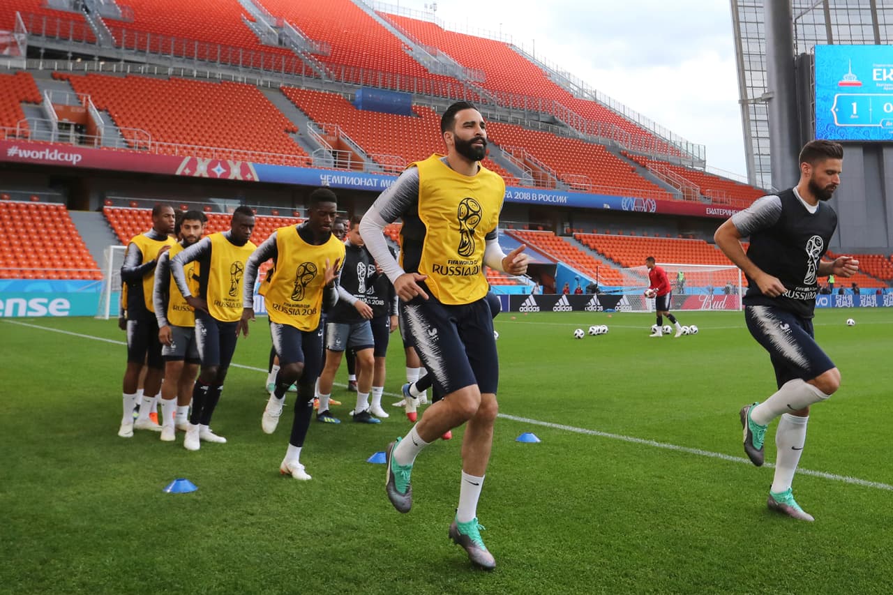 De derecha a izquierda en primer plano, Olivier Giroud y Adil Rami, hacen un poco de trote mientras se acostumbran al césped en el que jugarán en el Estadio Central este jueves.