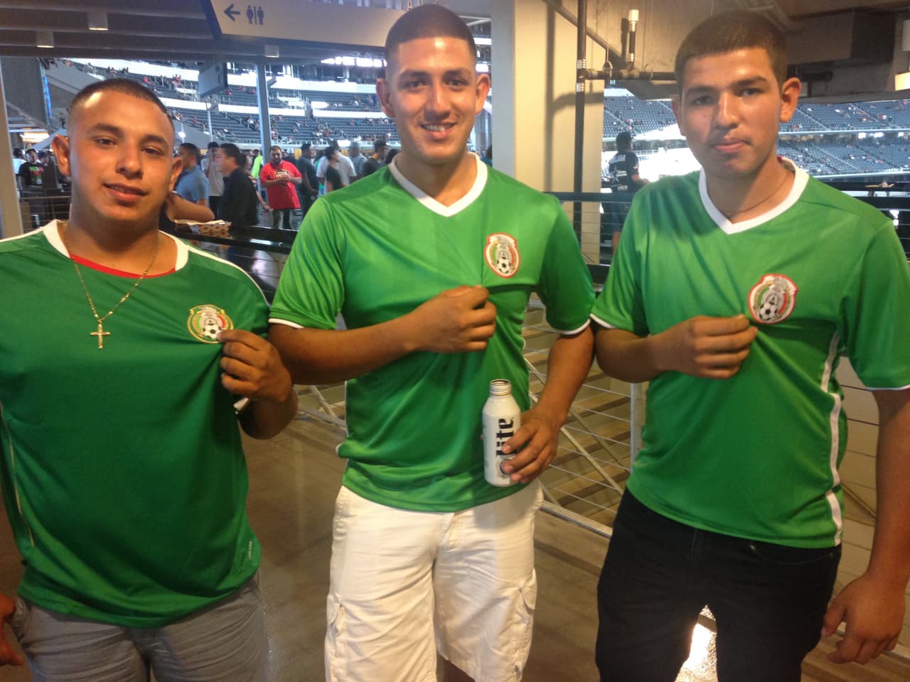Si no traes una playera con la leyenda de Saúl Álvarez, bien puedes utulizar el jersey de la selección mexicana. Aquí tres personas muestran el logo azteca.
