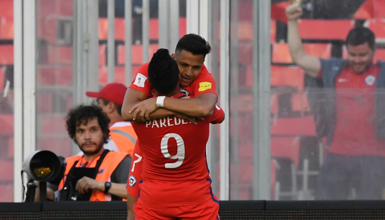 Chile's Esteban Paredes (bottom) celebrates with teammate forward Alexis Sanchez after scoring against Venezuela during their 2018 FIFA World Cup qualifier football match in Santiago, Chile on March 28, 2017. / AFP PHOTO / Martin BERNETTI (Photo credit should read MARTIN BERNETTI/AFP/Getty Images)