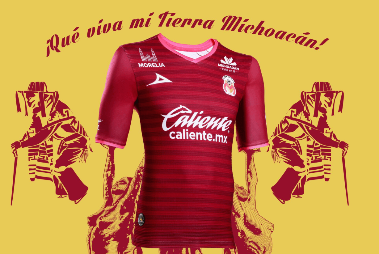 Su segunda equipación es de de color rojo con vivos de color rosa en el cuello y en las mangas de la playera. También resalta la catedral de Morelia.