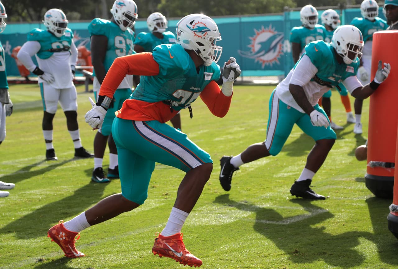 En primer plano aparece el ala defensivo de los Delfines de Miami Cameron Malveaux mientras ejecuta un ejercicio durante el entrenamiento de este lunes 30 de julio de 2018.