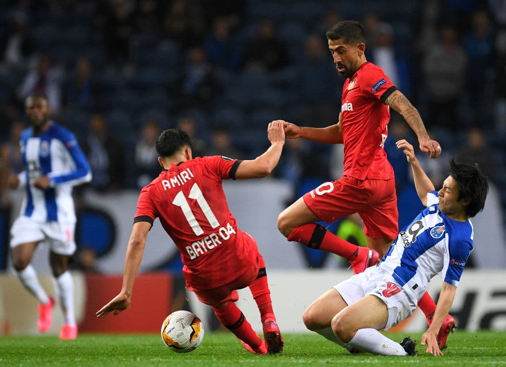Kerem Demirbay y Nadiem Amiri le cierran el paso al jugador japonés del Porto Shoya Nakajima.