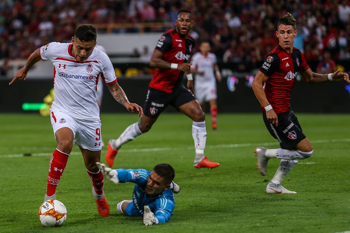 Otra ocasión de gol que salvó el arquero de Atlas, José Hernández, lanzándose a los pies de Ernesto Vega (izquierda) del Toluca.