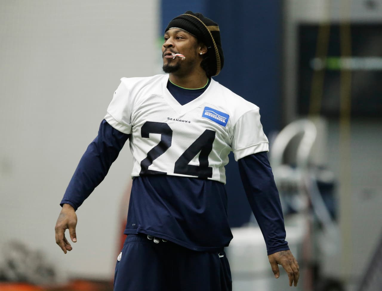 Seattle Seahawks running back Marshawn Lynch holds a candy cane in his mouth as he warms up before NFL football practice, Wednesday, Jan. 6, 2016, in Renton, Wash. Lynch has been recovering since having abdominal surgery last November. (AP Photo/Ted S. Warren)