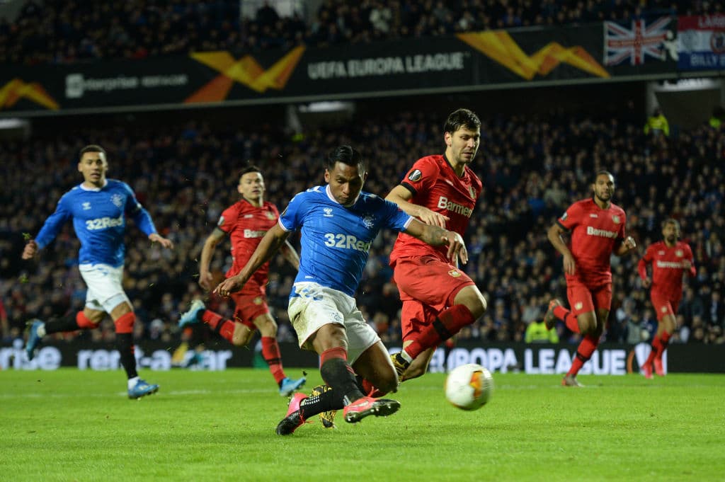 Alfredo Morelos porfin lográ ganar por velocidad y sacar el disparo, pero el disparo sale muy descompuesto.