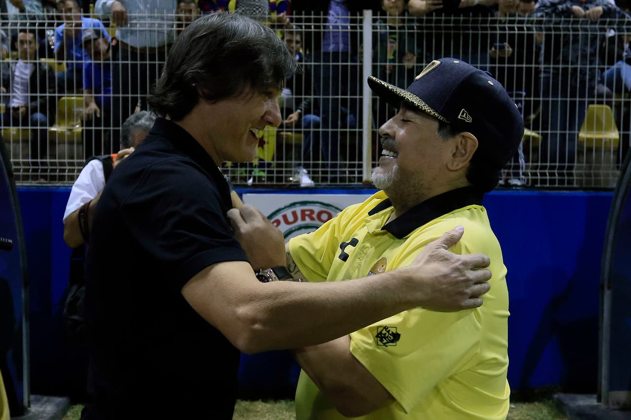 Gabriel Caballero y Diego Maradona muy contentos en el saludo previo al inicio del encuentro.