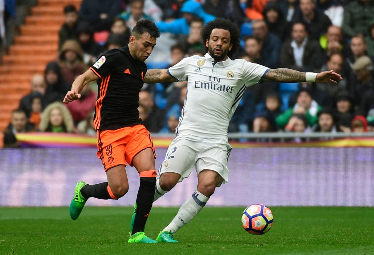 Real Madrid's Brazilian defender Marcelo (R) vies with Valencia's forward Munir El Haddadi during the Spanish league football match Real Madrid CF vs Valencia CF at the Santiago Bernabeu stadium in Madrid on April 29, 2017. / AFP PHOTO / PIERRE-PHILIPPE MARCOU (Photo credit should read PIERRE-PHILIPPE MARCOU/AFP/Getty Images)