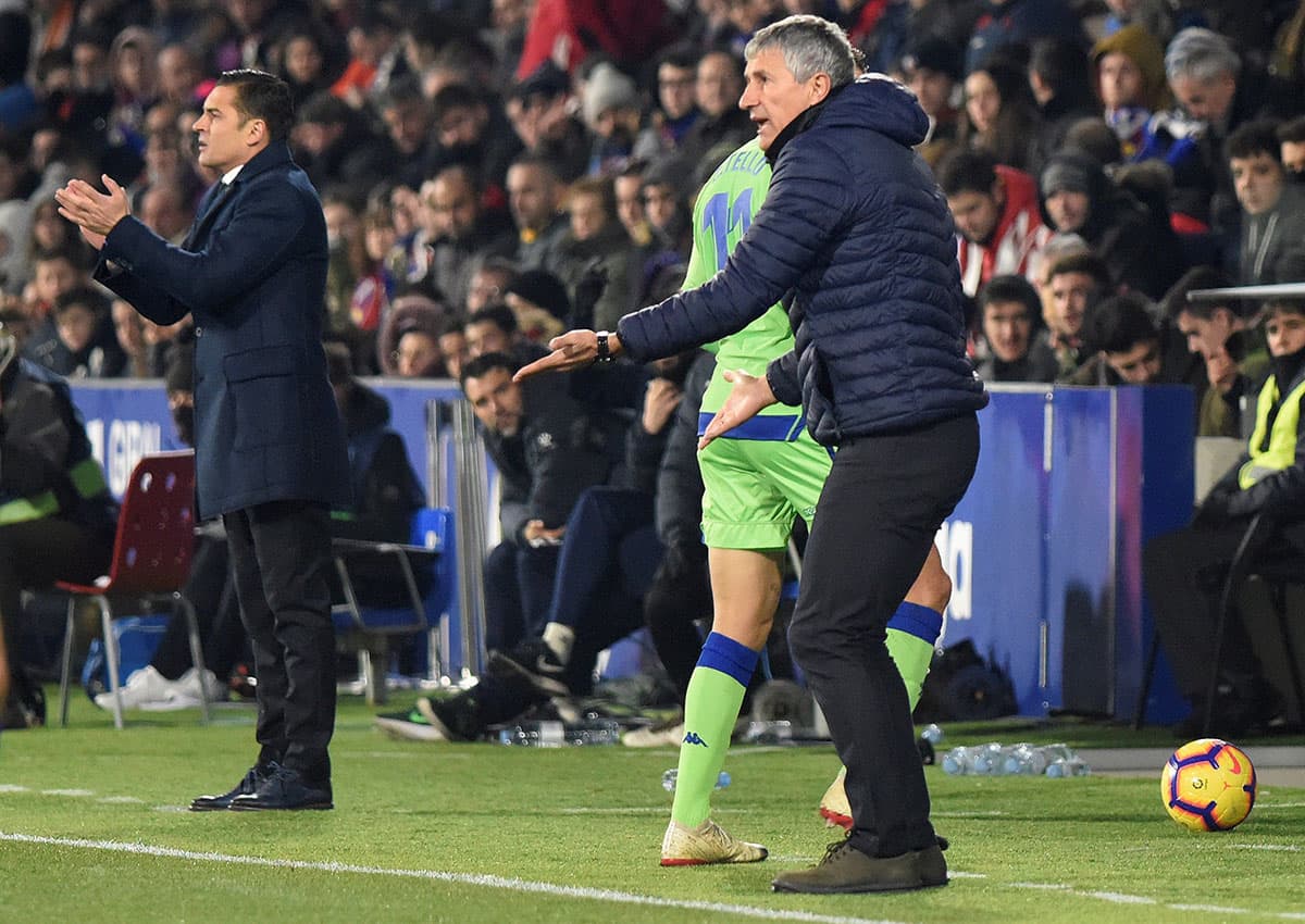 El entrenador del Real Betis Quique Setién (derecha) y Francisco Rodríguez (izquierda), entrenador del Huesca, durante el partido.