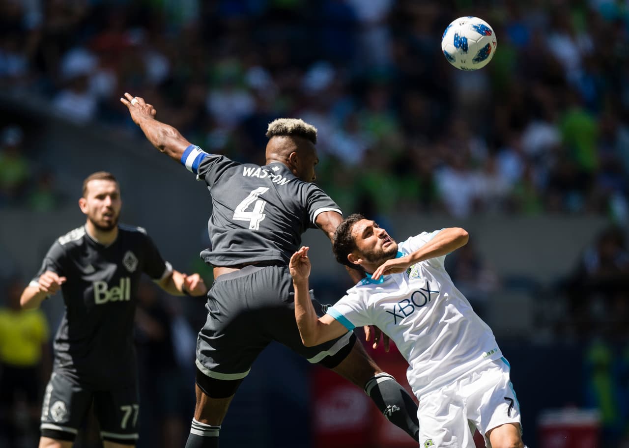 Jul 21, 2018; Seattle, WA, USA; Vancouver Whitecaps defender Kendall Waston (4) and Seattle Sounders midfielder Cristian Roldan (7) fight for position during the second half at CenturyLink Field. The Sounders won 2-0. Mandatory Credit: Troy Wayrynen-USA TODAY Sports