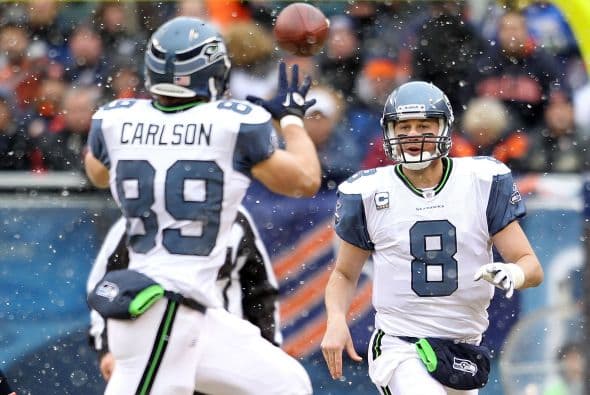 El quaterback de Seattle, Matt Hasselbeck #8, al momento de lanzar un pase a su ala cerrada John Carlson #89.