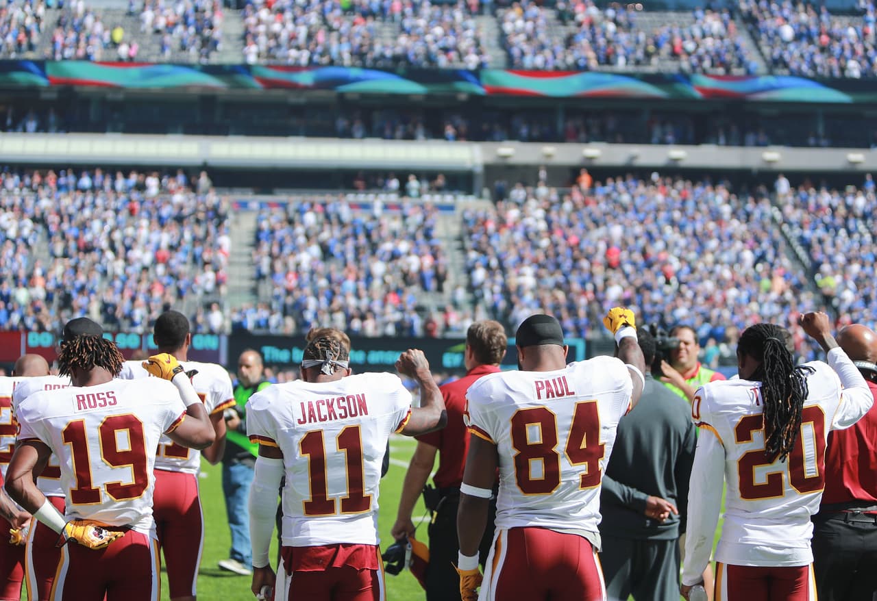 Algunos jugadores de los Washington Redskins elevaron el puño durante el himno.