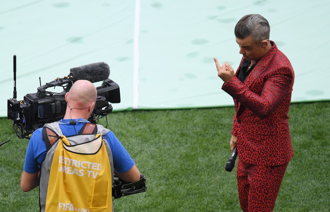 MOSCOW, RUSSIA - JUNE 14: (EDITORS NOTE: Image contains profanity.) Singer Robbie Williams gestures into a TV camera during the opening ceremony prior to the 2018 FIFA World Cup Russia Group A match between Russia and Saudi Arabia at Luzhniki Stadium on June 14, 2018 in Moscow, Russia. (Photo by Shaun Botterill/Getty Images)
