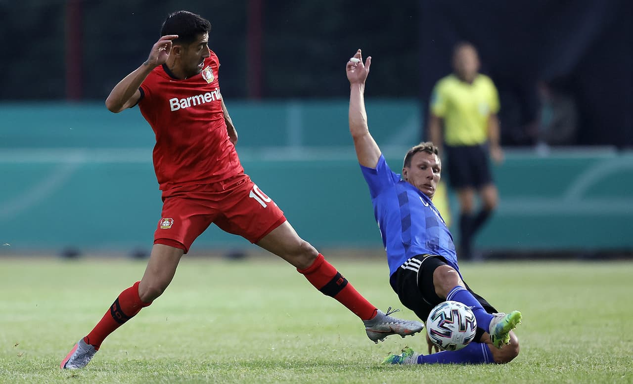Tobias Jaenicke se barre para evitar la avanzada del Leverkusen en piernas de Kerem Demirbay.