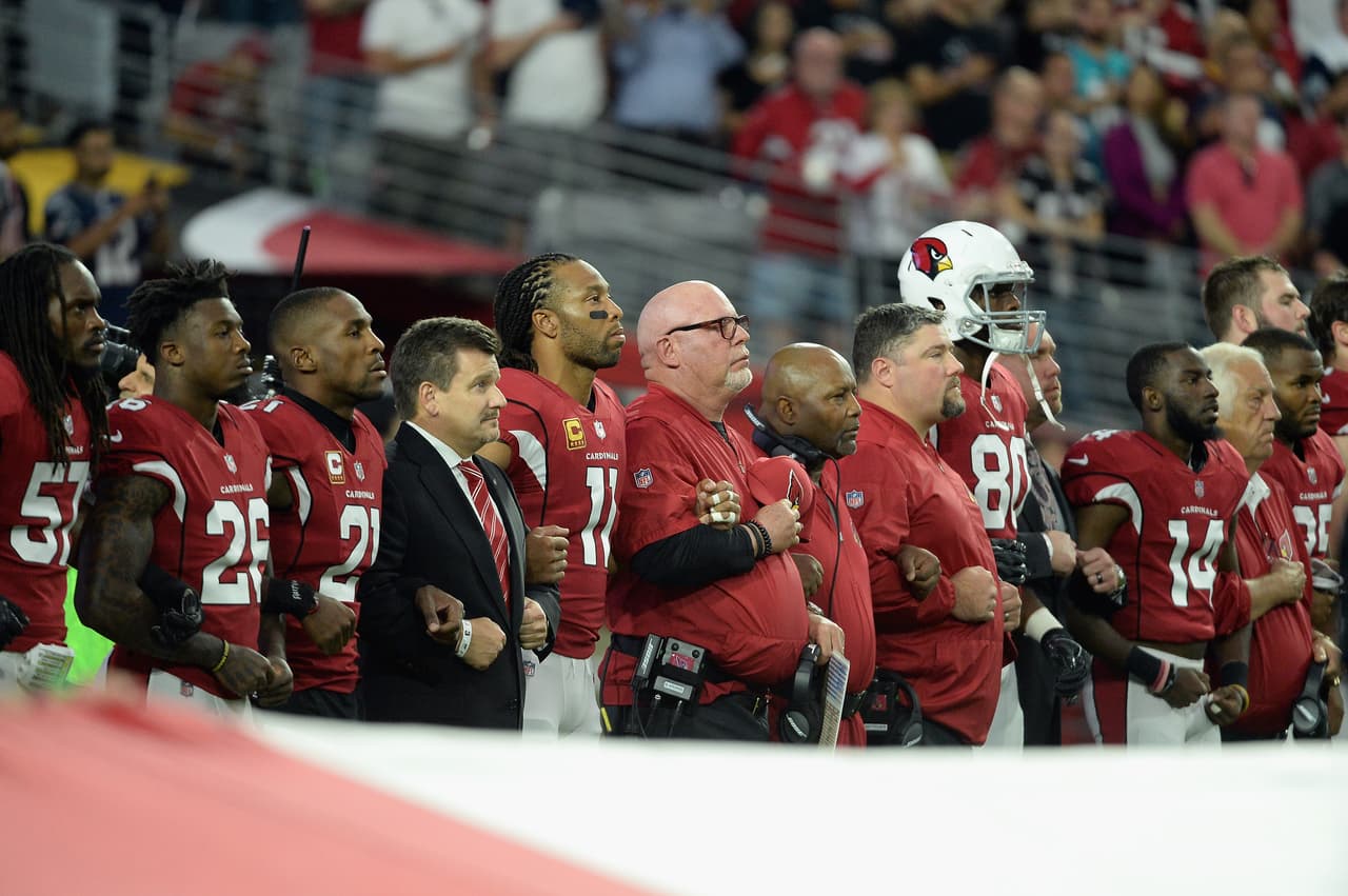 Dallas Cowboys y Arizona Cardinals con su respuesta ante el himno de los Estados Unidos en el University of Phoenix Stadium.