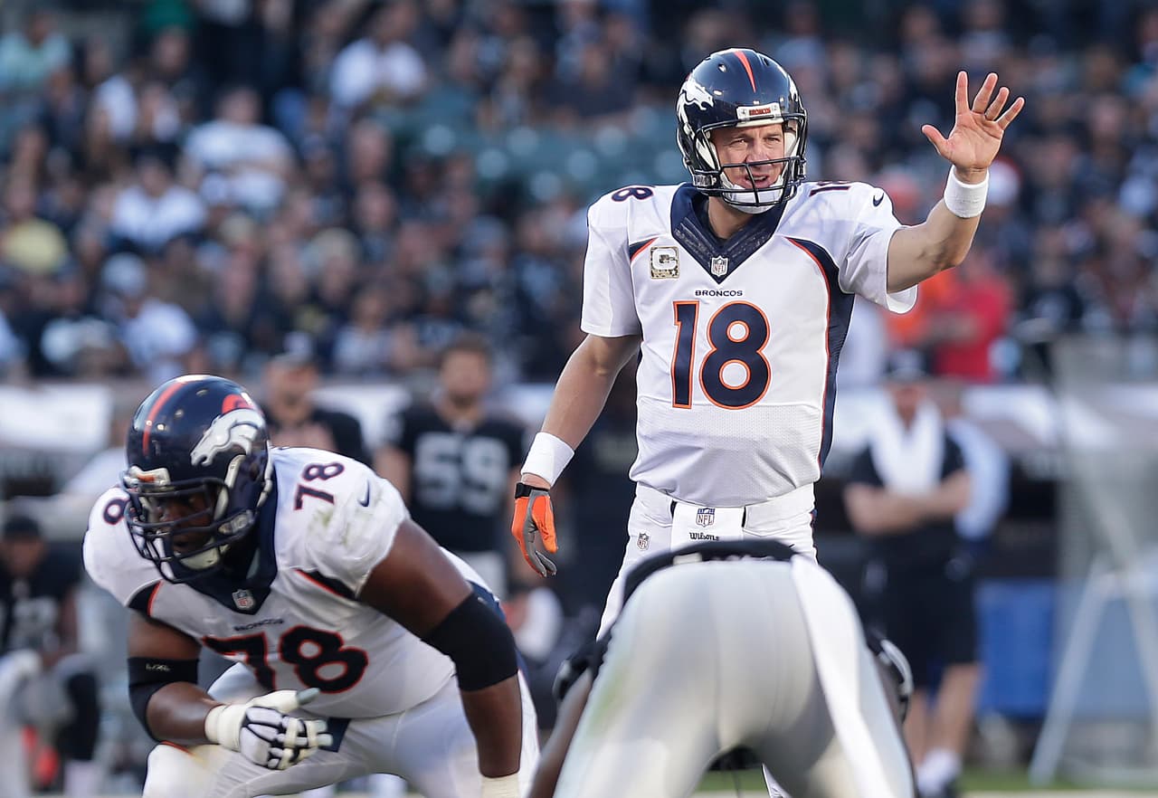 Denver Broncos quarterback Peyton Manning (18) signals at the line of scrimmage behind offensive tackle Ryan Clady (78) against the Oakland Raiders during the third quarter of an NFL football game in Oakland, Calif., Sunday, Nov. 9, 2014. (AP Photo/Marcio Jose Sanchez)
