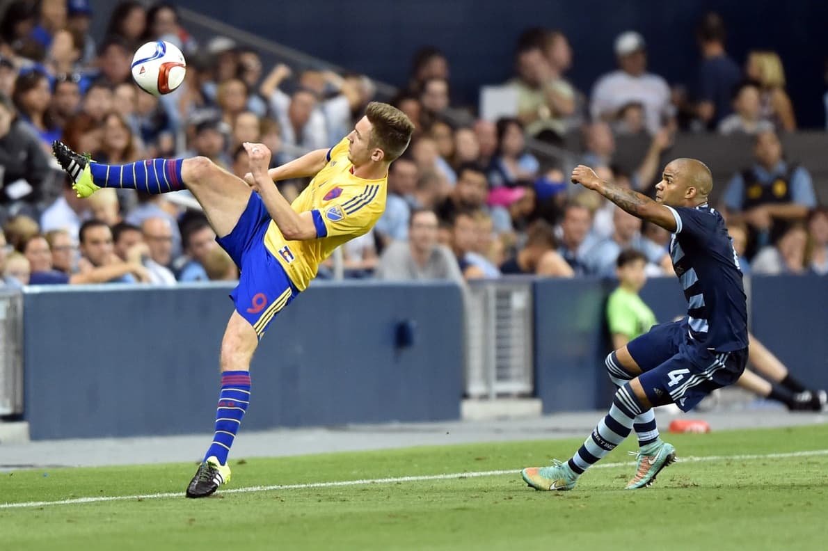 Control acrobático de Kevin Doyle para los Colorado Rapids, ante la atenta marca de Kevin Ellis.