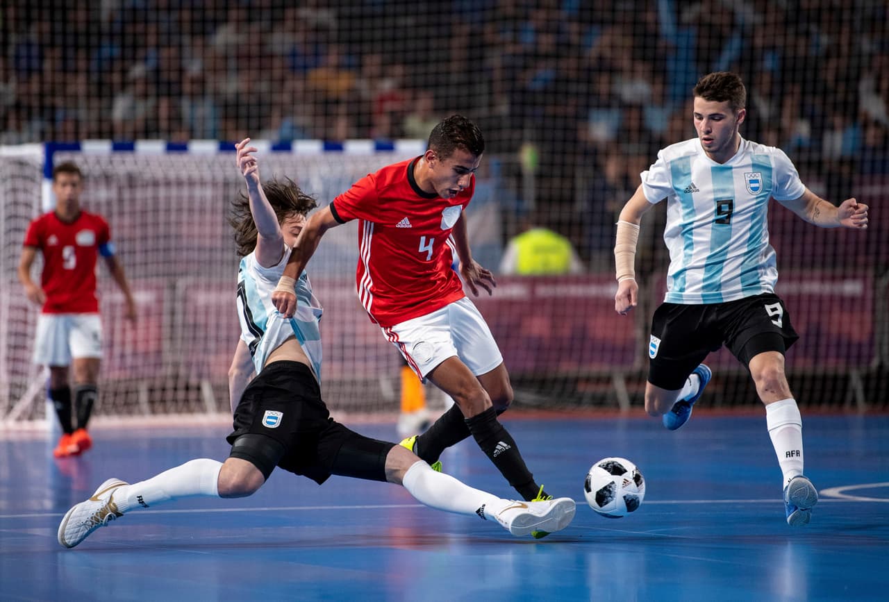 Agustin Raggiati de Argentina se barre para tratar de quitarle el balón a Moamen Hemdan Abdelraouf de Egipto en el partido por la medalla de bronce del Futsal para hombres en Parque Tecnópolis.