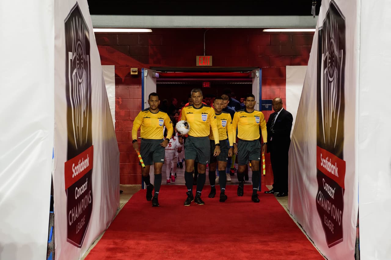 Los árbitros, encabezados por John Francis Pitti de Panamá, salen al Red Bull Arena de New Jersey.
