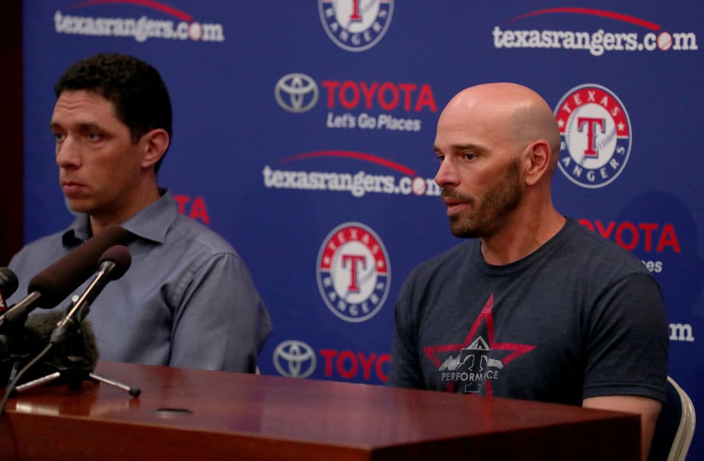 El gerente general de los Texas Rangers Jon Daniels (izq) y el manager de los Texas Rangers Chris Woodward, dieron una conferencia de prensa en Globe Life Park en Arlington donde hicieron el anuncio acerca de la cancelación del juego de este día a causa del infortunado deceso de Skaggs.