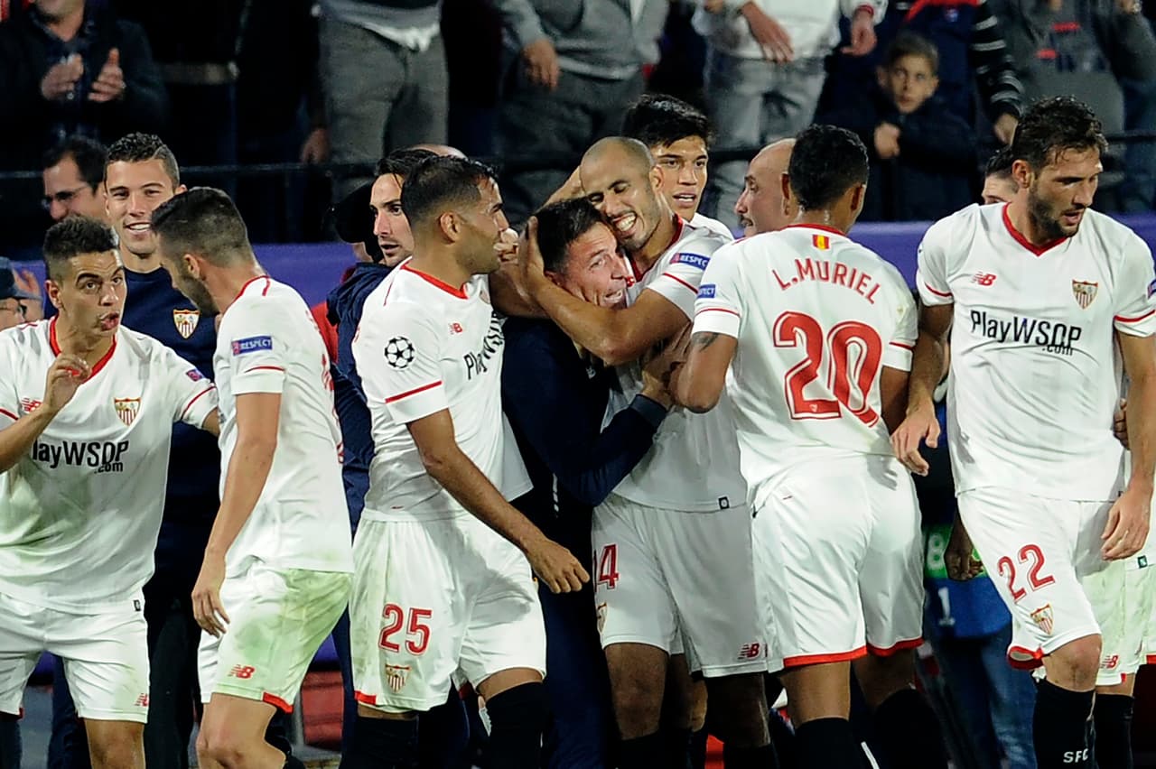 Sevilla's Argentinian midfielder Guido Pizarro (R) celebrates with Sevilla's Argentinian coach Eduardo Berizzo (L) after scoring a goal on November 21, 2017 at the Ramon Sanchez Pizjuan stadium in Sevilla during the UEFA Champions League group E football match between Sevilla FC and Liverpool FC. / AFP PHOTO / CRISTINA QUICLER (Photo credit should read CRISTINA QUICLER/AFP/Getty Images)