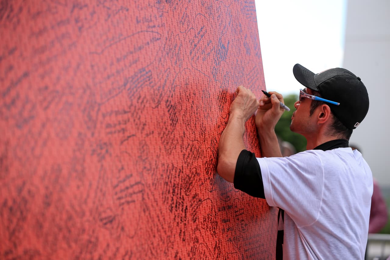 Ichiro Suzuki, experimentado jugador de los Marlins, escribe un mensaje en un muro conmemorativo a José Fernández en el Marlins Park.