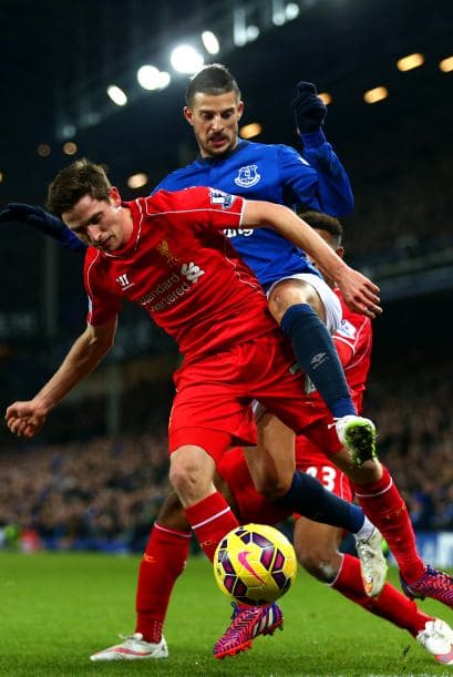 Liverpool, Inglaterra - 07 de febrero: Joe Allen de Liverpool batalla por el balón con Kevin Mirallas de Everton durante el partido de la Premier League entre el Everton y el Liverpool en el Goodison Park.