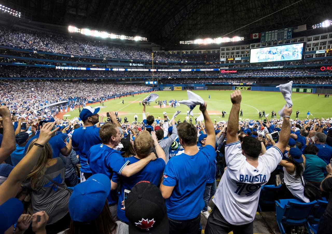 Fanáticos celebran la victoria de los Azulejos de Toronto contra los Rangers de Texas en la serie de playoffs de la Liga Americana el miércoles 14 de octubra de 2015. (Darren Calabrese/The Canadian Press via AP) MANDATORY CREDIT