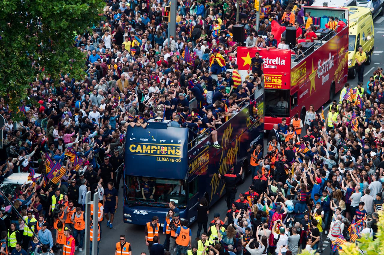 A ambos lados del autobús, el comportamiento de la seguidores culés era el de siempre. Miles y miles de personas -muchos padres con sus hijos- ataviados con 'senyeres' y bufandas y banderas del Barça y entregados a sus ídolos bajo una lluvia de confeti azul y grana.